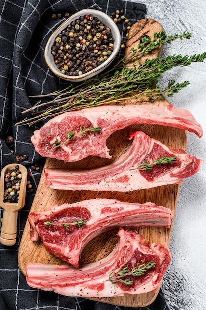 Raw fresh lamb ribs with pepper and thyme. Organic meat. White background. Top view