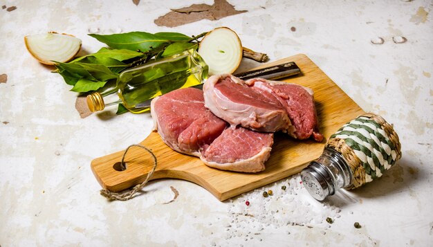 スパイスを添えた生の新鮮な肉。素朴な背景に。