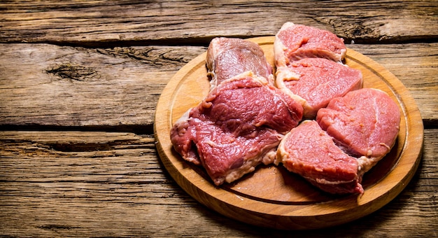 Raw fresh meat on cutting board. On wooden table.