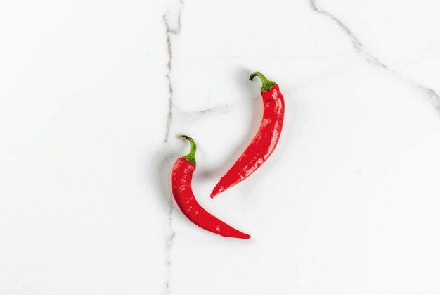 Raw fresh organic chili pepper on white marble  top view 