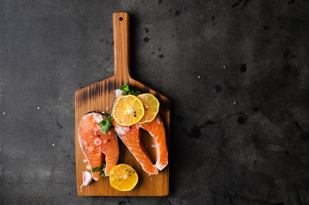 Raw fresh organic salmon fish steaks on a wooden cutting board