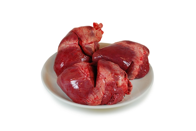 Raw fresh pork hearts on a dish isolated against white background