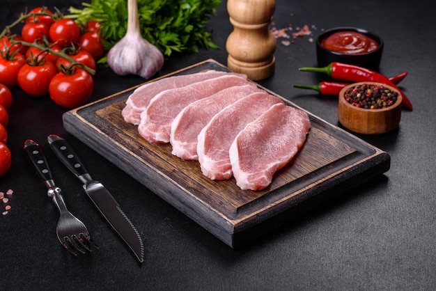 木製のまな板でスライスした生の新鮮な豚肉