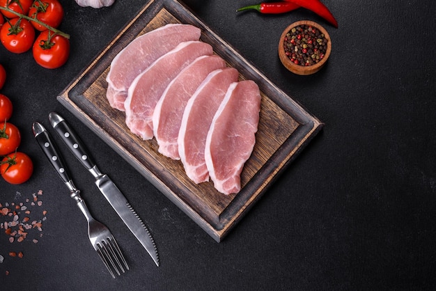 Raw fresh pork meat sliced on a wooden cutting board