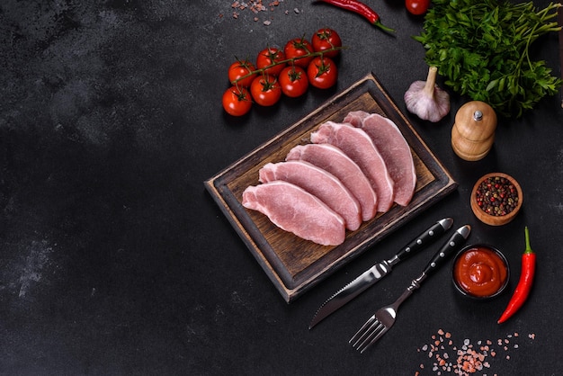 Raw fresh pork meat sliced on a wooden cutting board