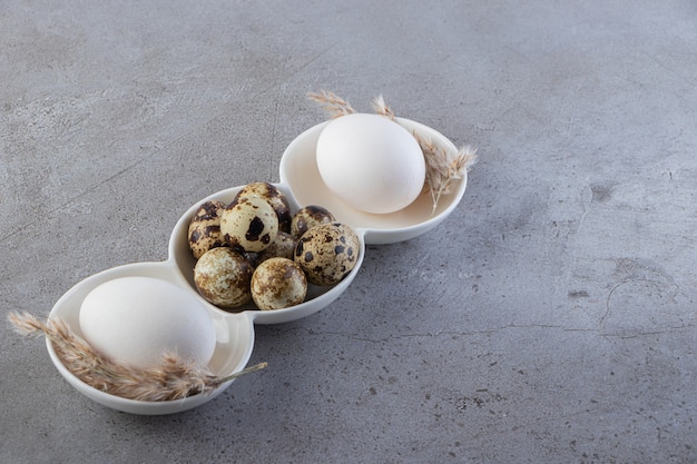 Raw fresh quail eggs placed on a stone table.