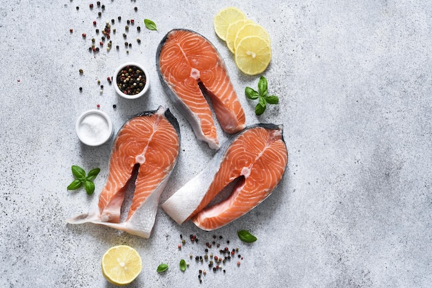 Raw fresh red fish with lemon basil on a concrete background. Salmon steak.