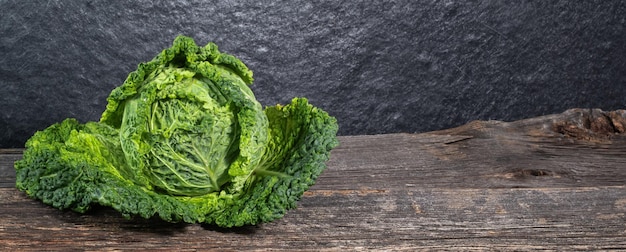 Raw fresh savoy cabbage on wooden background rustic concept