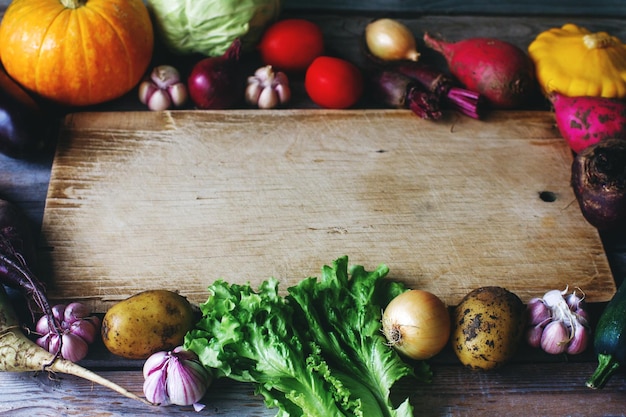 Raw fresh vegetables on wooden board in rustic style