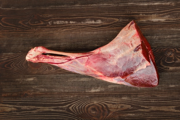 Raw fresh young beef leg on wooden background