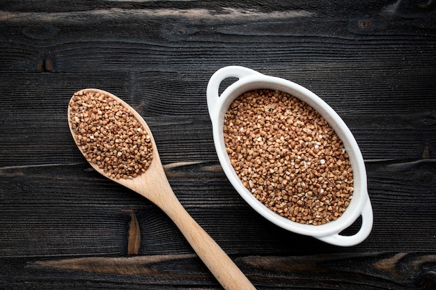 Raw fried buckwheat grains in white bowls - flat lay