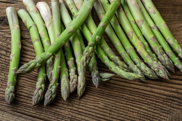 Foto steli di asparagi di giardino grezzi verdure di primavera fresche su sfondo di legno