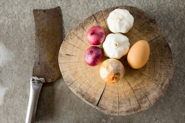 Raw garlic,onion,shallot,egg on cutting board