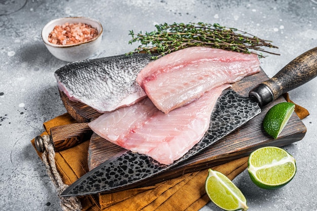 Raw Gilthead Sea bream fish fillets on a butcher cutting board Gray background Top view