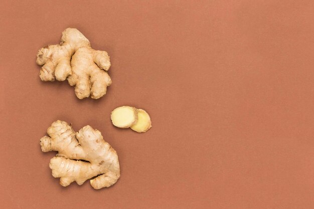 Photo raw ginger root and dry ginger on brown background products for immunity