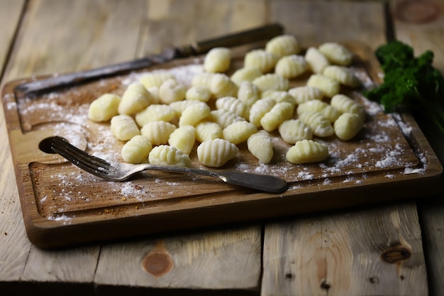 Foto gnocchi crudi su una tavola di legno.