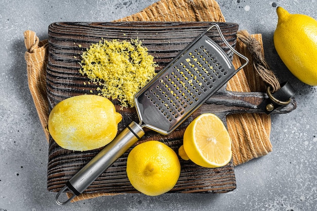 Raw grated Lemon Zest peel on wooden board Gray background Top view