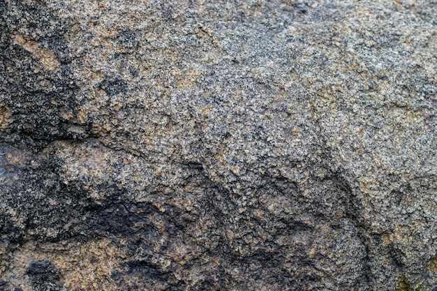 Raw gray granite rock texture background Fragment of natural stone wall