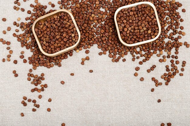 Raw gray peas in wooden bowls on light tablecloth with copy space. Organic healthy diet food. Traditional Latvian product. Legumes bean seed.