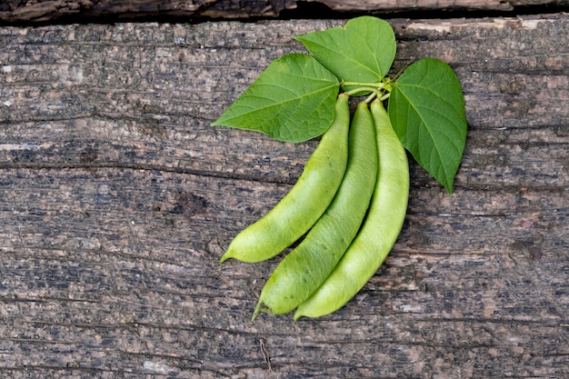 Raw green beans on wood. Closeup.