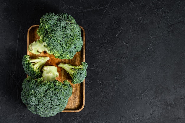 Raw green broccoli on a wooden bowl