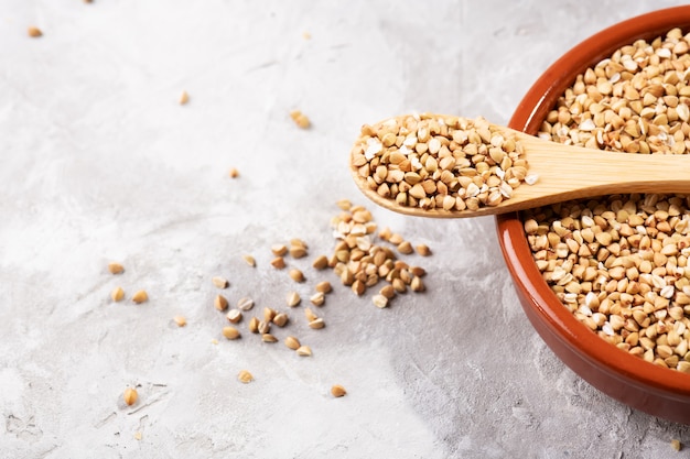 Raw green buckwheat in a brown clay bowl