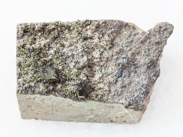 Raw green crystals of Epidote on rock on white