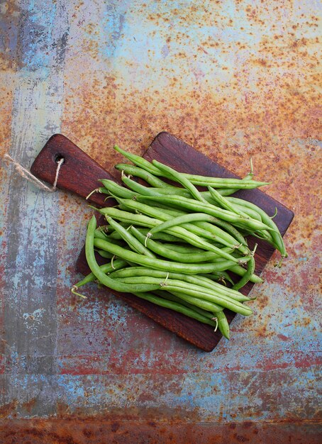 Photo raw green string beans on an old metal background