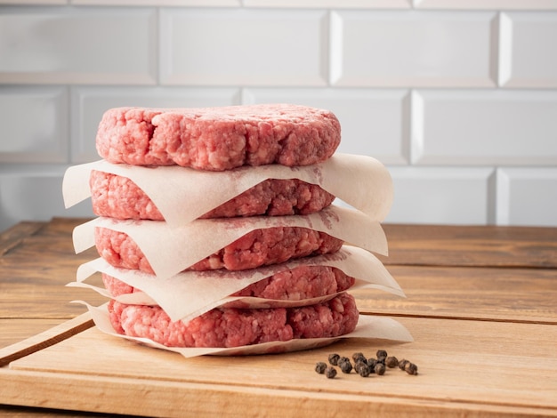 Photo raw ground beef burger patties separated by baking paper