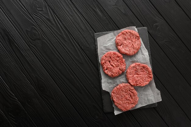 Raw Ground beef meat Burger steak cutlets on dark wooden background