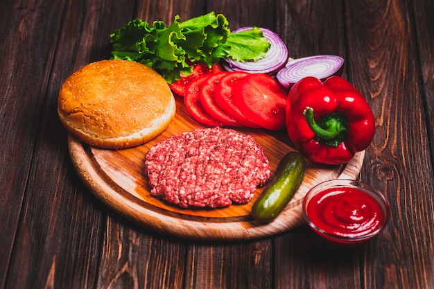 Raw Ground beef meat Burger steak cutlets with seasoning, cheese