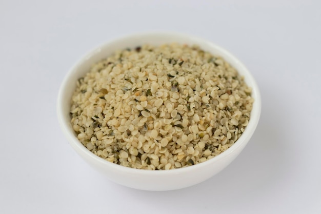 Raw hemp kernels in a small plate on a white background Omega 3