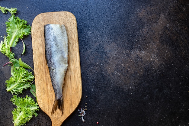 Raw herring fish on a wooden board