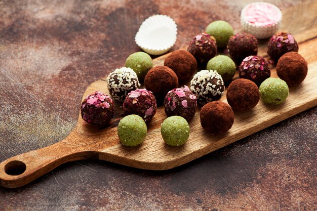 Raw homemade candy truffles on a wooden board