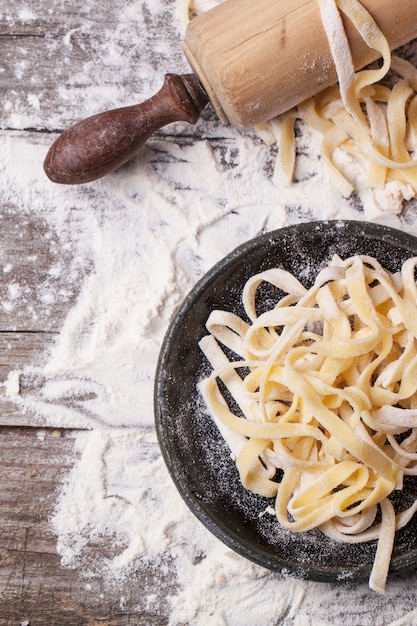 Raw homemade pasta with rolling pin