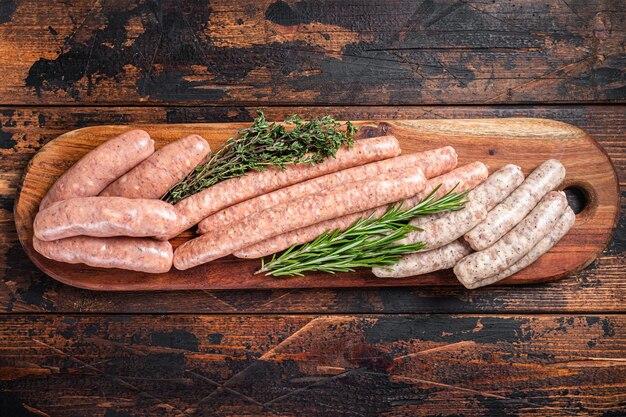 Raw homemade sausages with Beef pork lamb and chicken mince meat on a wooden board Wooden background Top view