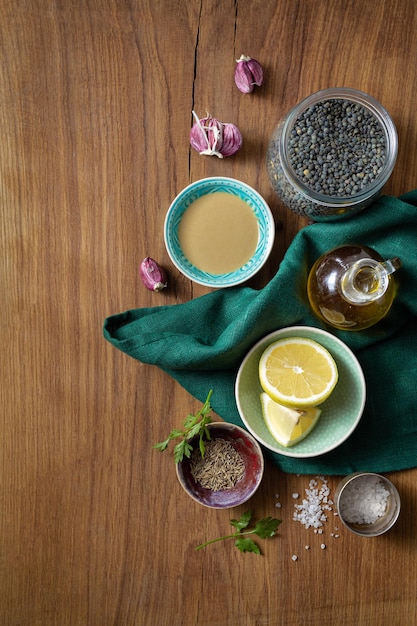 Raw ingredients for cooking green lentil hummus on wooden table