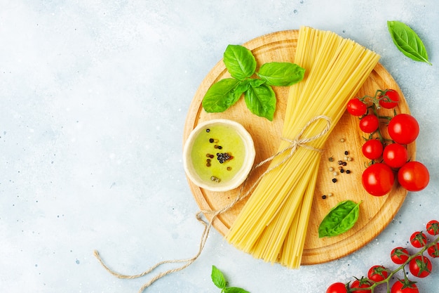 Raw ingredients for cooking pasta on grey stone background