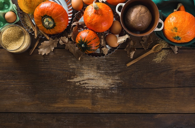 Raw ingredients for cooking pumpkin pie with dry autumn leaves 