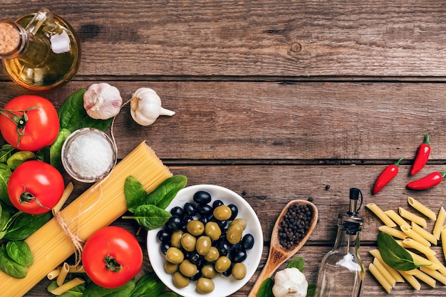 Foto materie prime per la preparazione della pasta italiana spaghetti basilico pomodori olive e olio d'oliva o