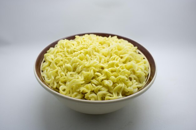 Raw instant noodle served on bowl isolated white background