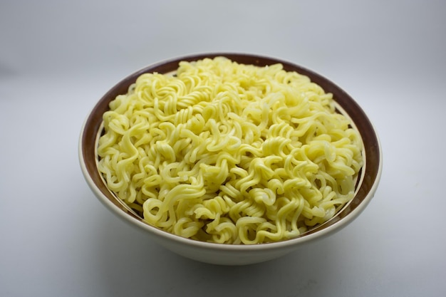 Raw instant noodle served on bowl isolated white background