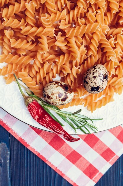 Raw italian pasta on dark blue wooden table, top view