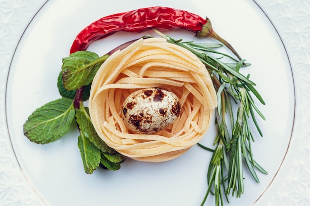 Raw italian pasta on dark blue wooden table, top view