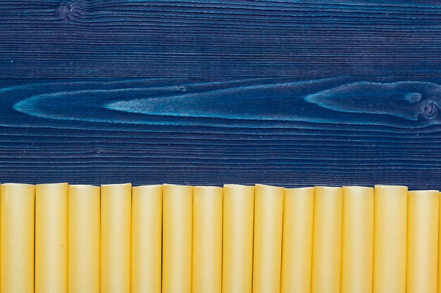 Raw italian pasta on dark blue wooden , top view