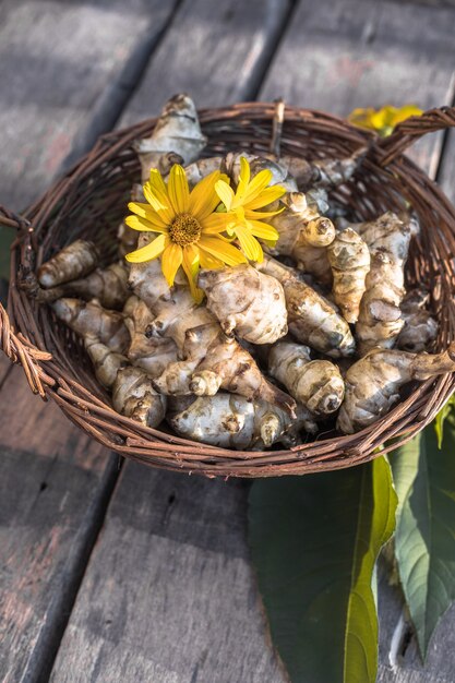 Raw jerusalem artichoke. Topinambur vegetable root on wooden table.