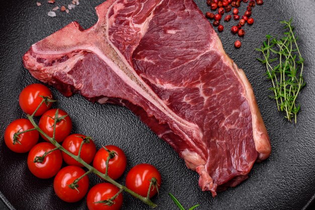 raw juicy beef tbone steak with salt spices and herbs