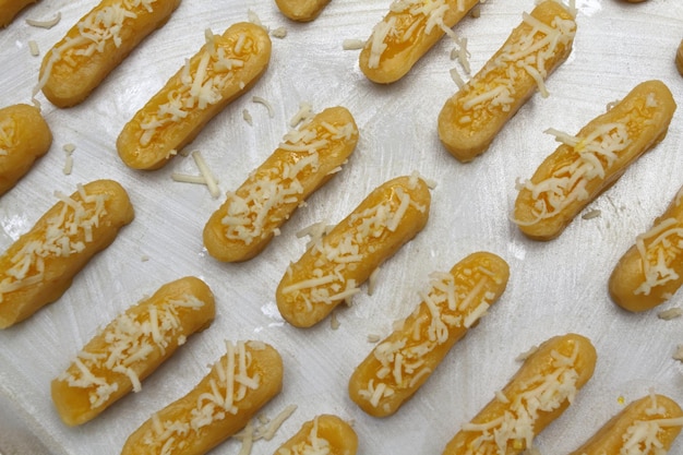 Photo raw kaasstengels dutch cheese finger cookies dough on aluminum tray are ready to bake