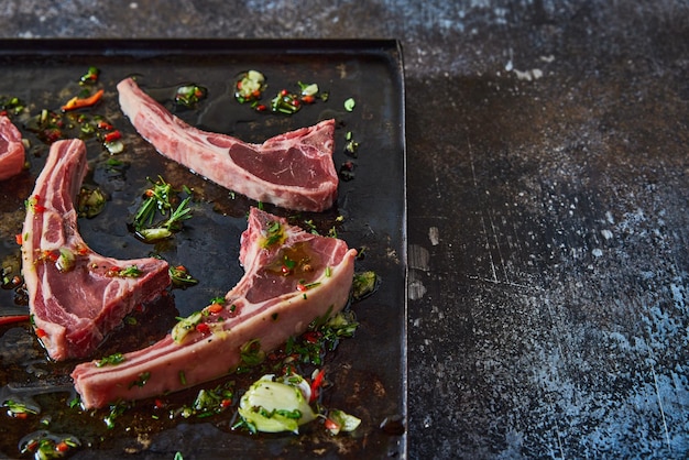 Raw lamb chops on baking pan