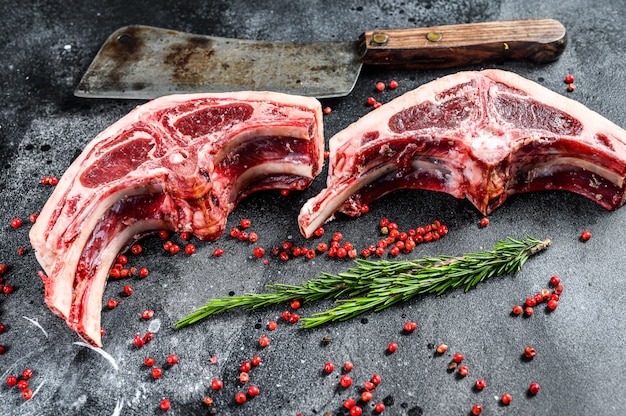 Raw lamb chops fresh cut with meat cleaver. Black background. Top view